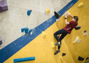 Niña participando en la liga infantil de escalada en un rocódromo Climbat